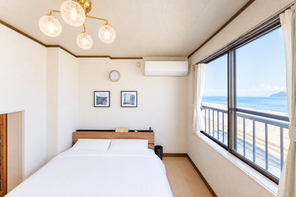 A bedroom with windows facing the sea